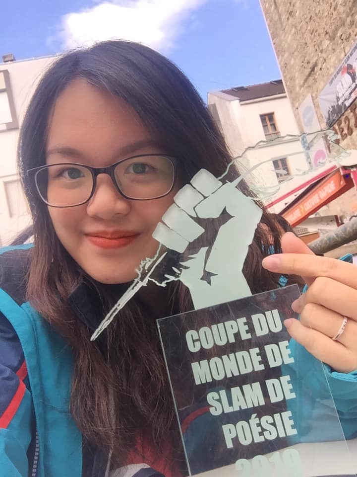 Quán quân Slam thơ Việt Nam 2019- Nguyễn Thùy Linh bên Cup chứng nhận tham dự Slam thơ Quốc tế 2019 